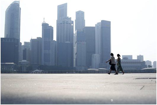 2 person walking with city buildings in background