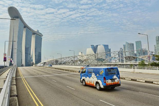 blue printed van passing a bridge