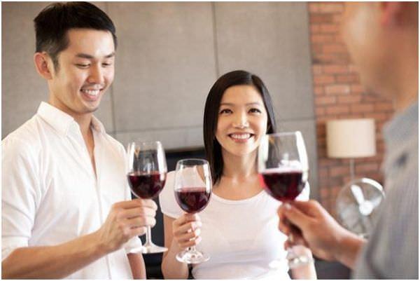 a man and woman holding a glass with wine