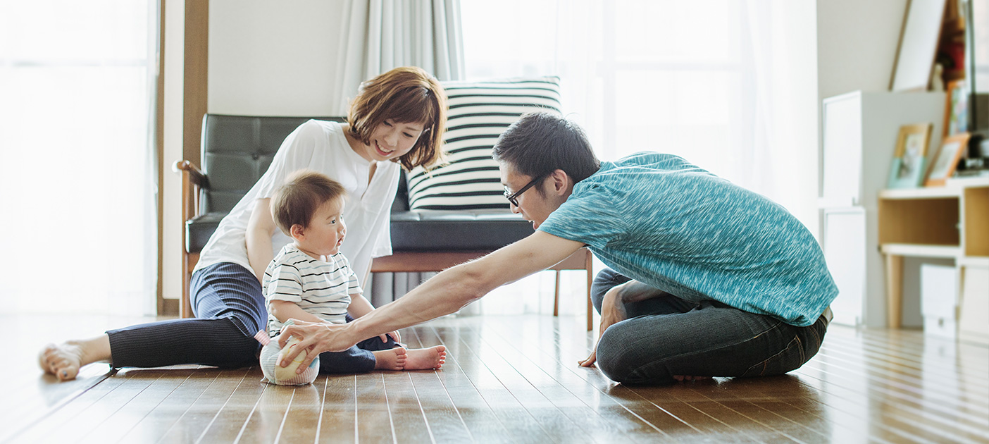 Couple playing with young child in their new house.