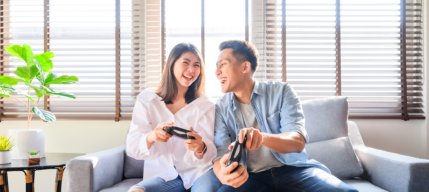 Young couple enjoying their new house by gaming together.
