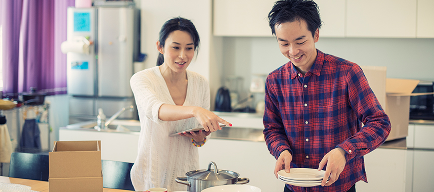 Young couple pack their kitchen as they get ready to move