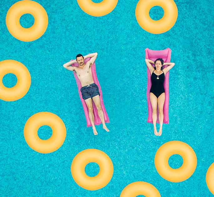 A couple bask on floats in a swimming pool