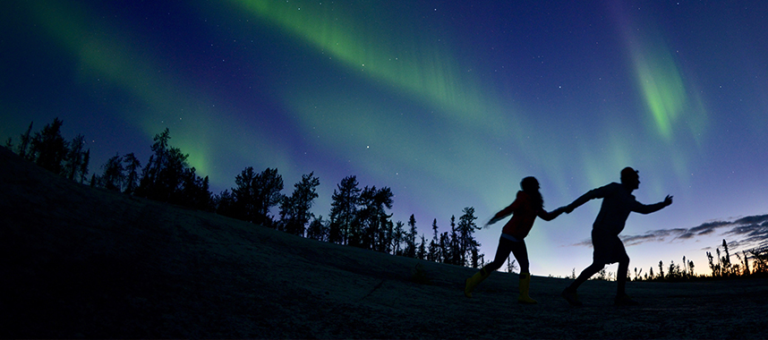 A young couple make a memorable escapade under the blue-green glow of the Northern Lights
