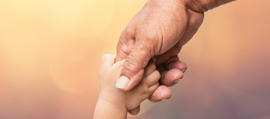 Hand of an older adultholding the tiny hand of a toddler