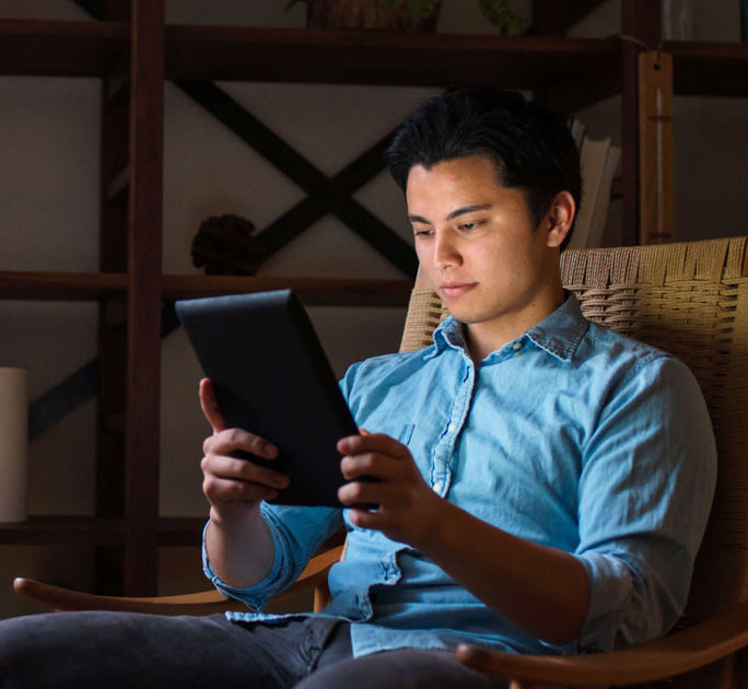 Man reads up on investing from his iPad