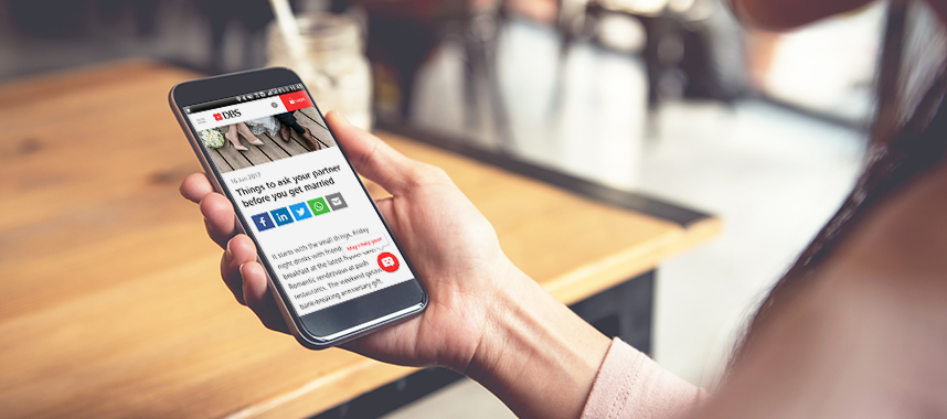 A woman browsing through an article on talking about finances with loved ones at a cafe