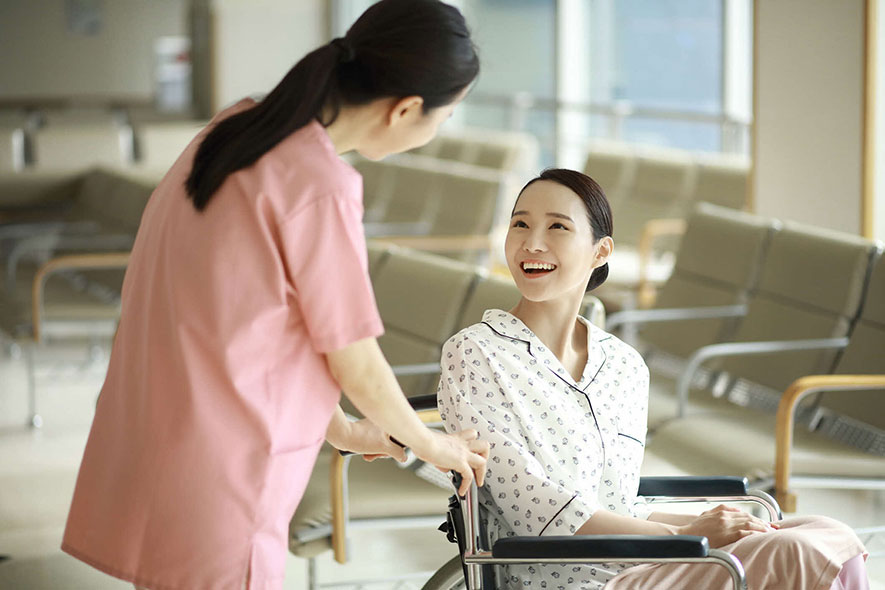 Nurse talking woman in wheelchair